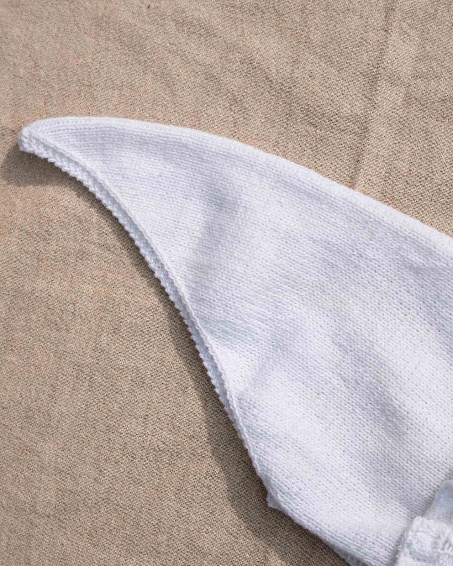 Et tidløst og søtt skaut med blondekant rundt ansiktet. Hele skautet strikkes frem og tilbake. Det plukkes opp masker til halskant, og til blondekant rundt ansiktet. Vakker, enkel og tidløst design.