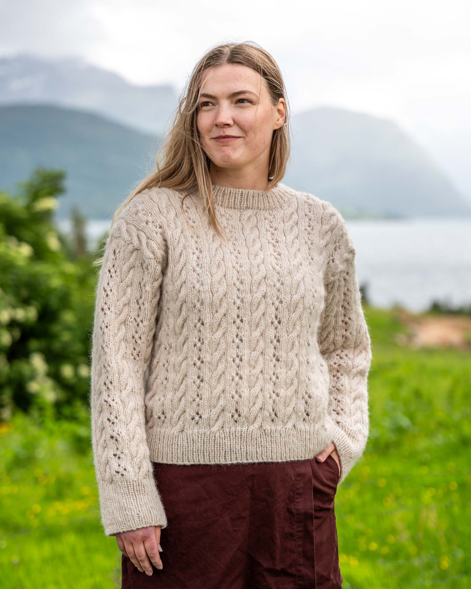 Berntine Sweater er en lekker strukturstrikket genser med fletter og hullmønster. Like fin til jeans som over sommerkjolen. Genseren strikkes nedenfra og opp og det plukkes opp masker til ermene som strikkes ovenfra og ned. Elegant og tidløst design.
