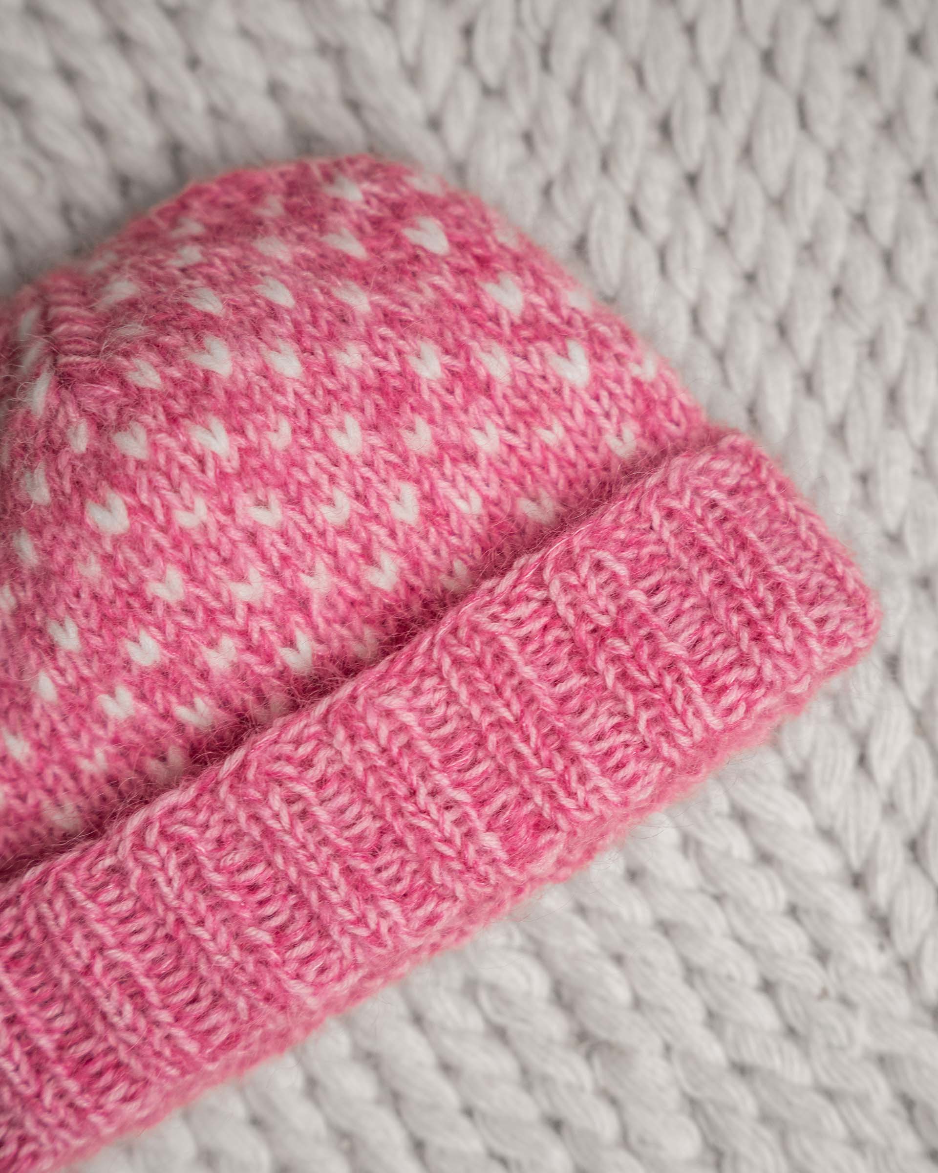 En drøm av en lue, fargerik og myk. Strikket i trippelt garn for å få en lekker melering. Lusene strikkes i enkel tråd. Utrolig søt med rosa melering.
