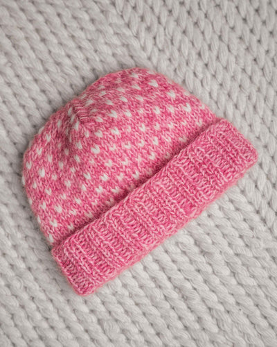 En drøm av en lue, fargerik og myk. Strikket i trippelt garn for å få en lekker melering. Lusene strikkes i enkel tråd. Trendy lue strikket i garn fra Sandnes. Her i en rosa fargekombinasjon