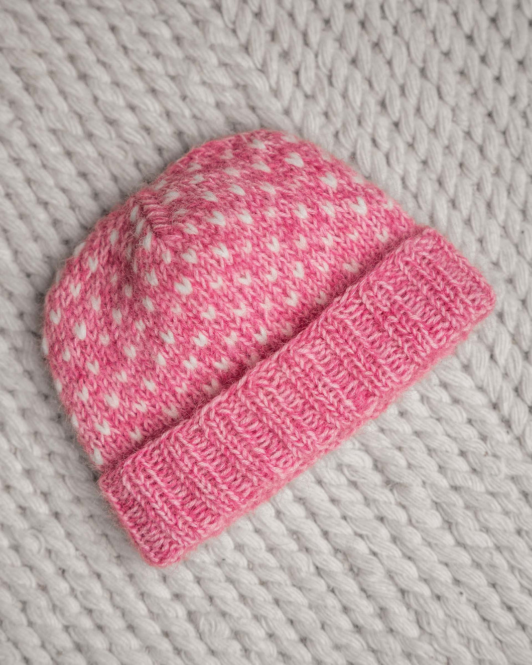 En drøm av en lue, fargerik og myk. Strikket i trippelt garn for å få en lekker melering. Lusene strikkes i enkel tråd. Trendy lue strikket i garn fra Sandnes. Her i en rosa fargekombinasjon