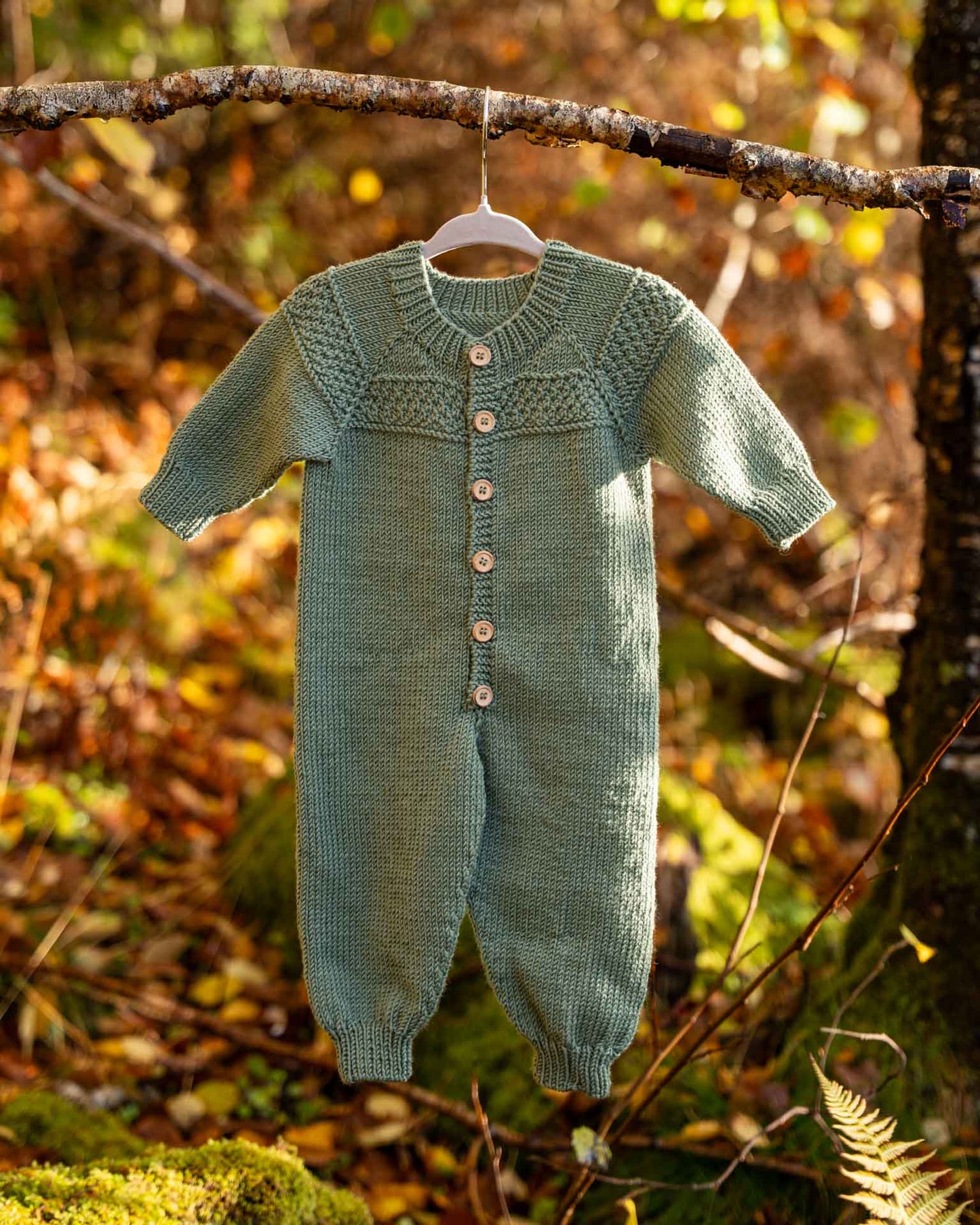 Hans babydress er en søt dress med perlestrikket bord på bærestykket. 
Dressen strikkes ovenfra og ned med raglanøkninger. Halsutringingen dannes ved vendepinner og stolpen strikkes i riller samtidig som resten av arbeidet. 
Dressen er enkel og stilfull og passer til både jenter og gutter.