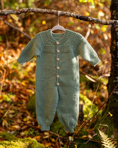 Hans babydress er en søt dress med perlestrikket bord på bærestykket. 
Dressen strikkes ovenfra og ned med raglanøkninger. Halsutringingen dannes ved vendepinner og stolpen strikkes i riller samtidig som resten av arbeidet. 
Dressen er enkel og stilfull og passer til både jenter og gutter.