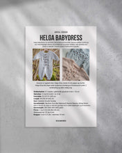Last inn bildet i Galleri-visningsprogrammet, Helga babydress er en søt dress med struktur på fremsiden. Dressen strikkes ovenfra og ned, halsutringingen dannes ved vendepinner og stolpen strikkes i riller samtidig som resten av arbeidet. 
