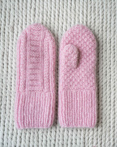 Strikkeoppskrift på Ingelin Tovavotter med strukturstrikk på begge sider. Flette og rillestrikk på framside og dobbel perlestrikk på baksiden. Av bildet i Rosa med Fritidsgarn fra Sandnes
