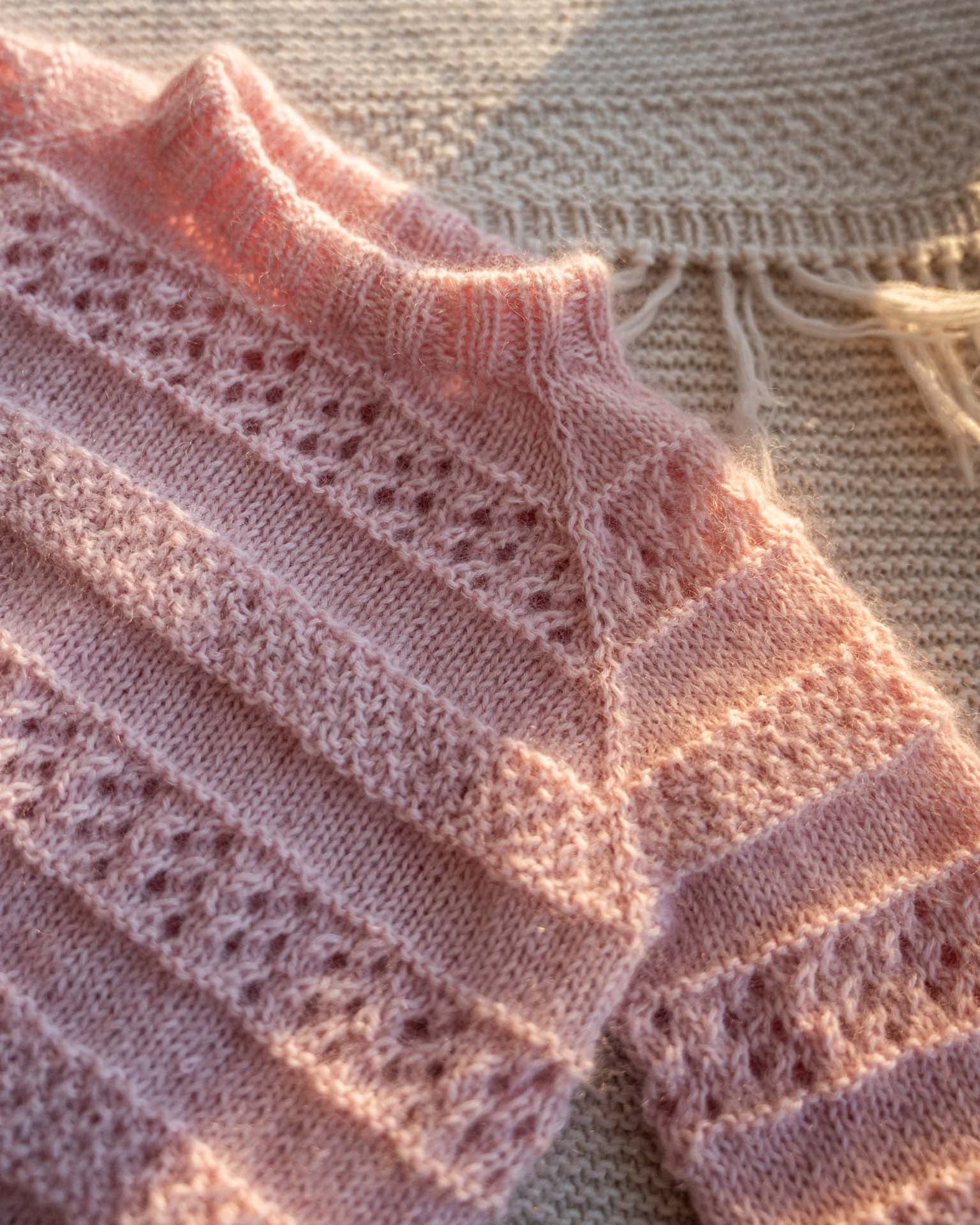 En søt genser i en blanding av mohair, silke og merinoull. Den er strukturstrikket med hullmønster og dobbel perlestrikk. Søt Mama and me match.