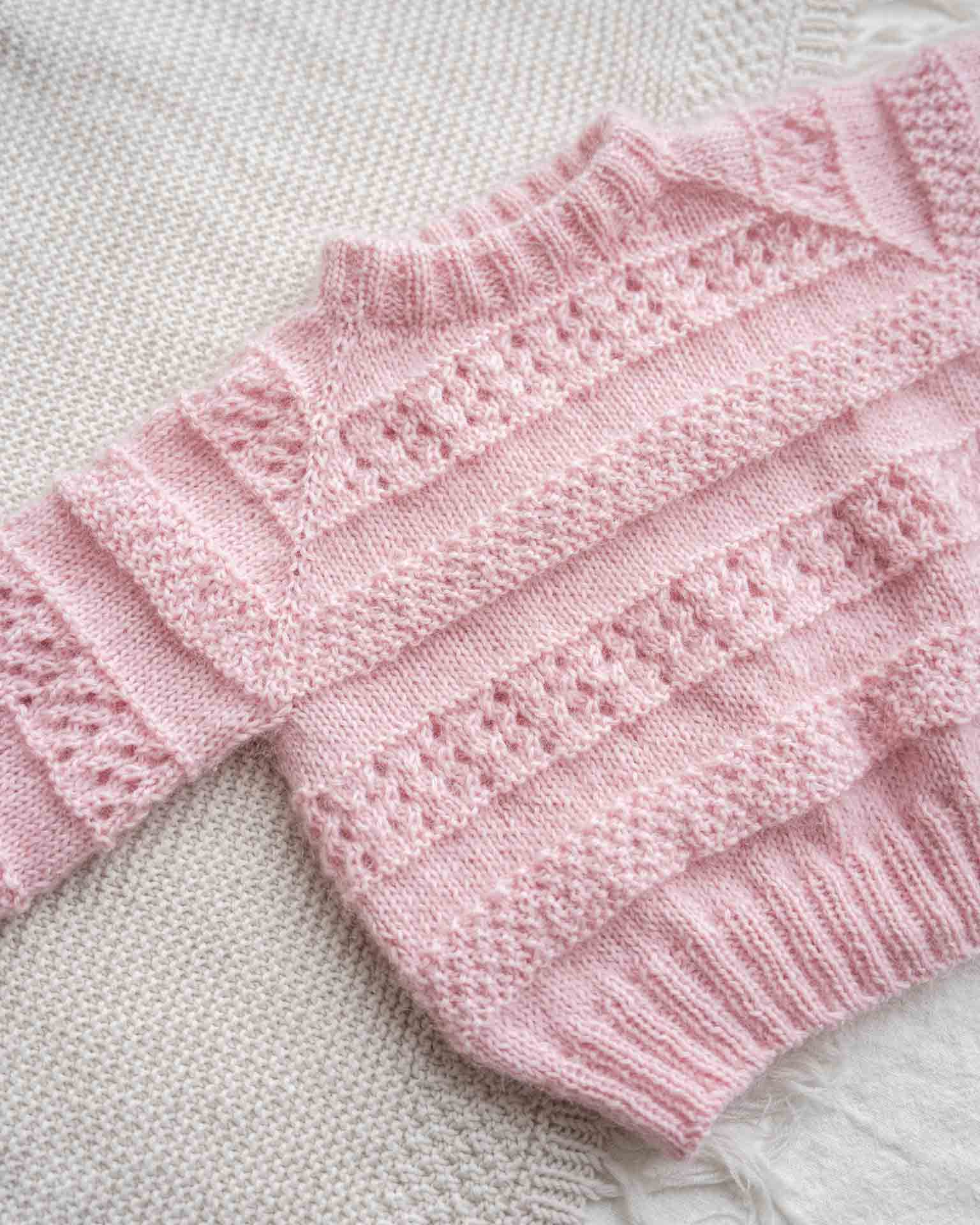 En søt genser i en blanding av mohair, silke og merinoull. Den er strukturstrikket med hullmønster og dobbel perlestrikk. Kommer i størrelse til barn og dame og er en nydelig mamma og mini-match.