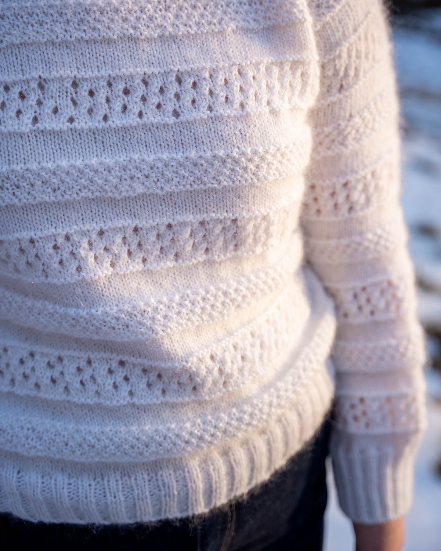 Karen Sweater er en søt genser i en blanding av mohair, silke og merinoull. Den er strukturstrikket med hullmønster og dobbel perlestrikk.