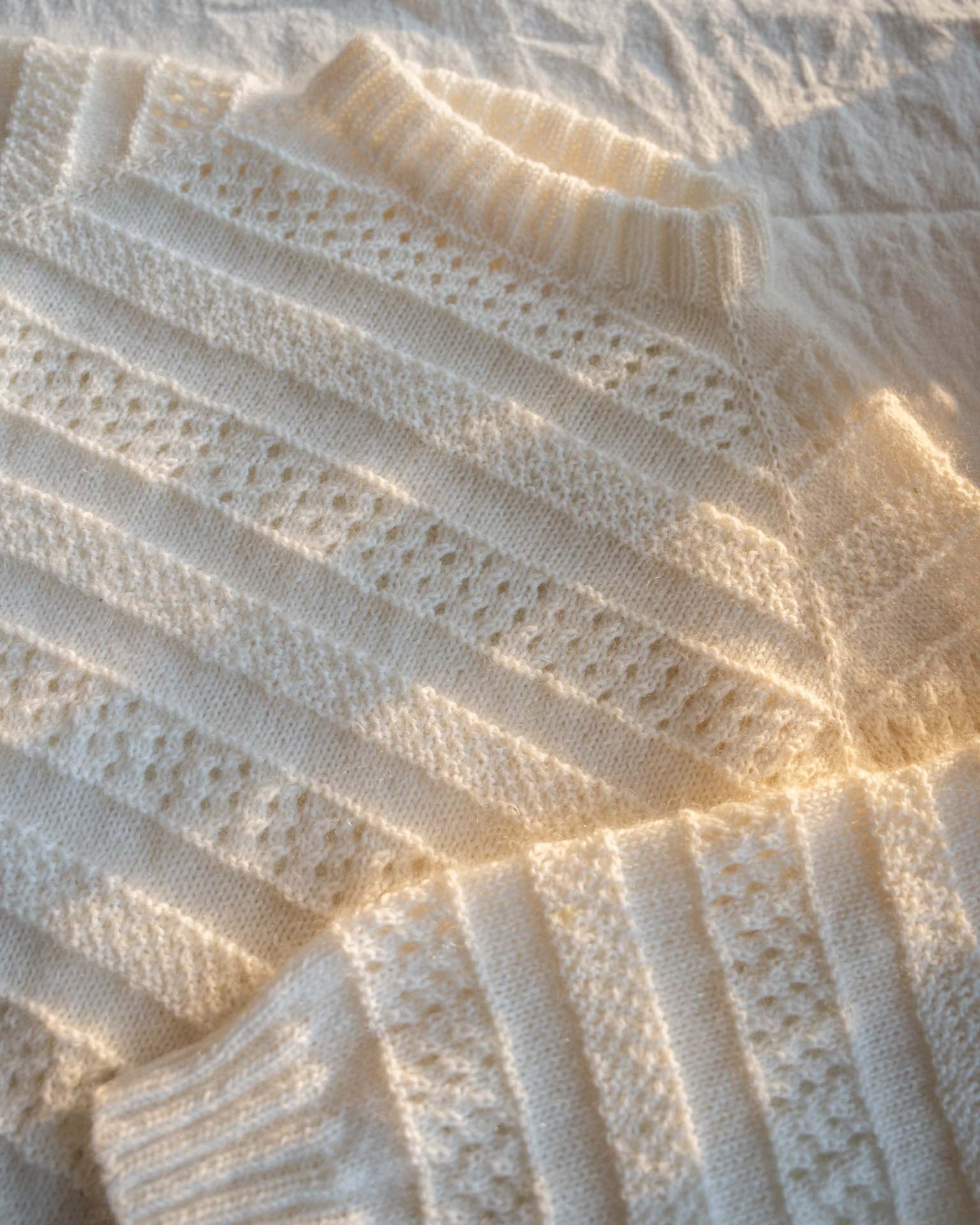 En pyntet genser i en blanding av mohair, silke og merinoull. Den er strukturstrikket med hullmønster og dobbel perlestrikk. 