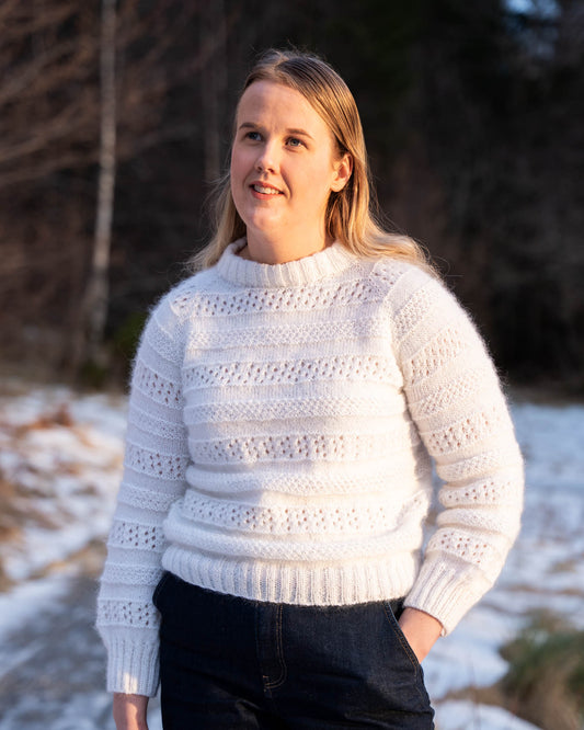 Karen Sweater er en søt genser i en blanding av mohair, silke og merinoull. Den er strukturstrikket med hullmønster og dobbel perlestrikk. 