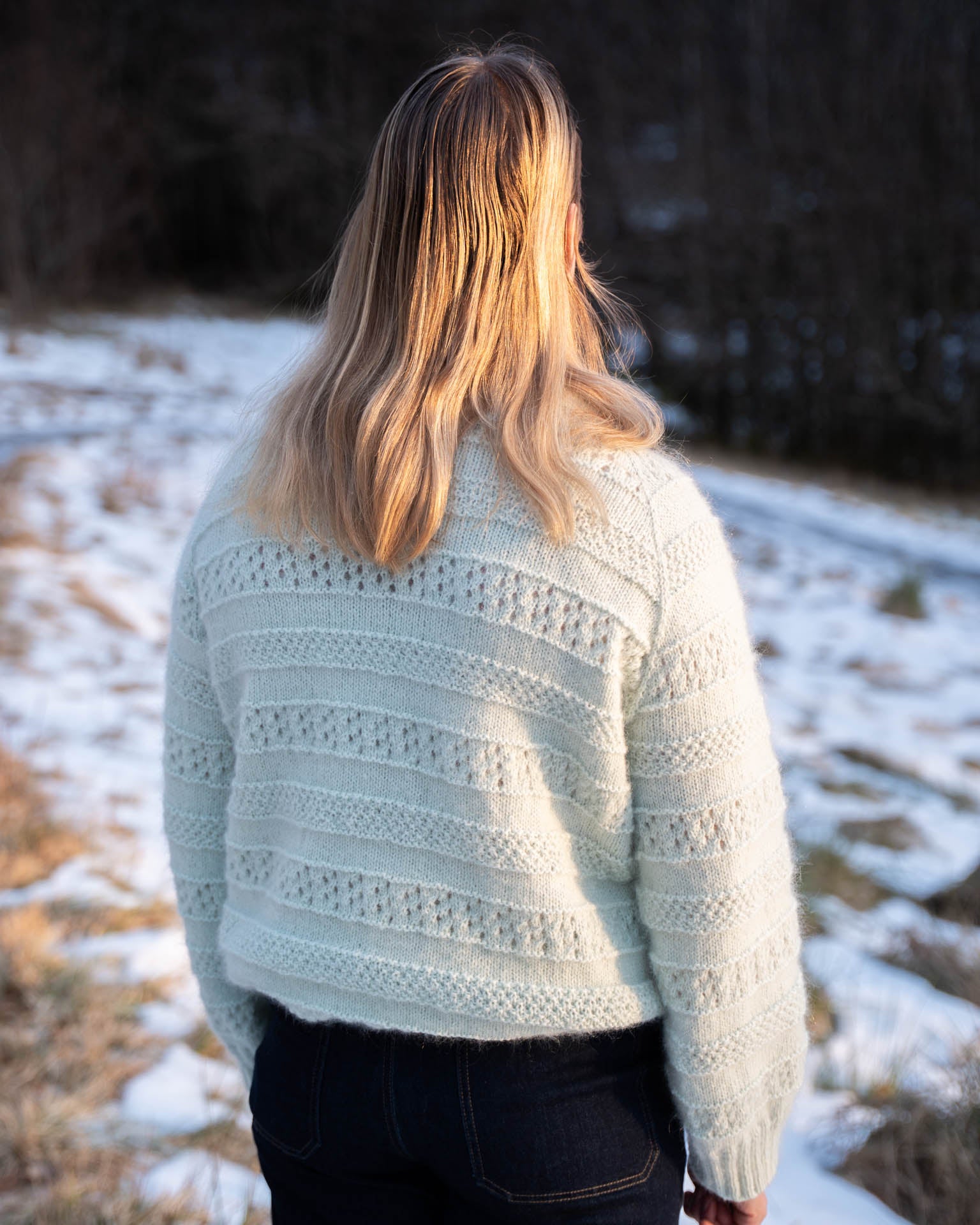 En elegant strikkegenser i en blanding av mohair, silke og merinoull. Den er strukturstrikket med hullmønster og dobbel perlestrikk. Ryggen av Karen genseren.