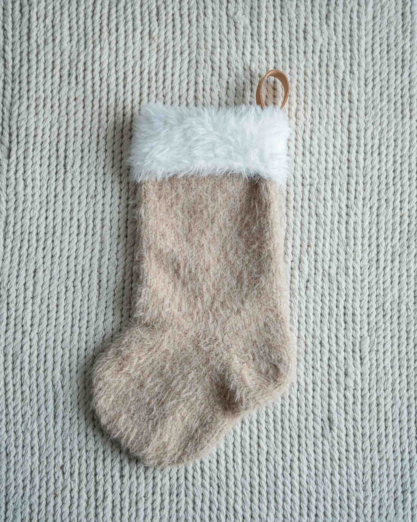 Mons julestrømpe er en klassisk julestrømpe med pelskant og skinnhempe. 
Julestrømpen kommer i tre ulike størrelser og har god hold slik at den henger pent. I trendy beige farge.