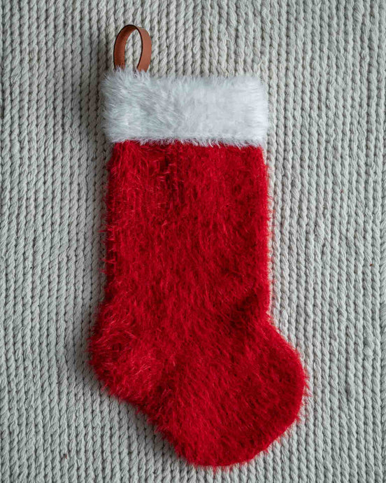 Mons julestrømpe er en klassisk julestrømpe med pelskant og skinnhempe. 
Julestrømpen kommer i tre ulike størrelser og har god hold slik at den henger pent. 