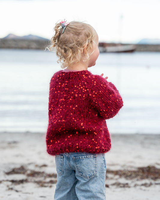 Henrikke Sweater Barn fra Løvoll Design, en festlig barnegenser med paljetter.