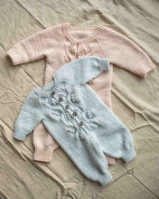 Last inn bildet i Galleri-visningsprogrammet, Helga babydress er en søt dress med struktur på fremsiden. Dressen strikkes ovenfra og ned, halsutringingen dannes ved vendepinner og stolpen strikkes i riller samtidig som resten av arbeidet. Dressen passer til både jenter og gutter.
