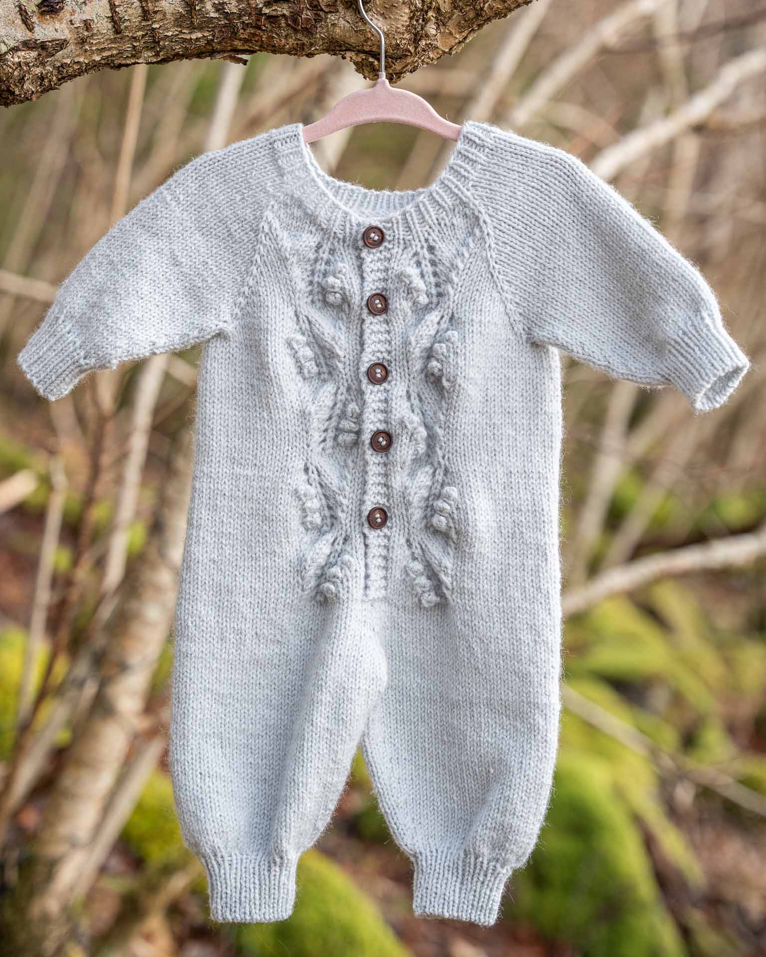 Helga babydress er en søt strikkesdress med struktur på fremsiden.